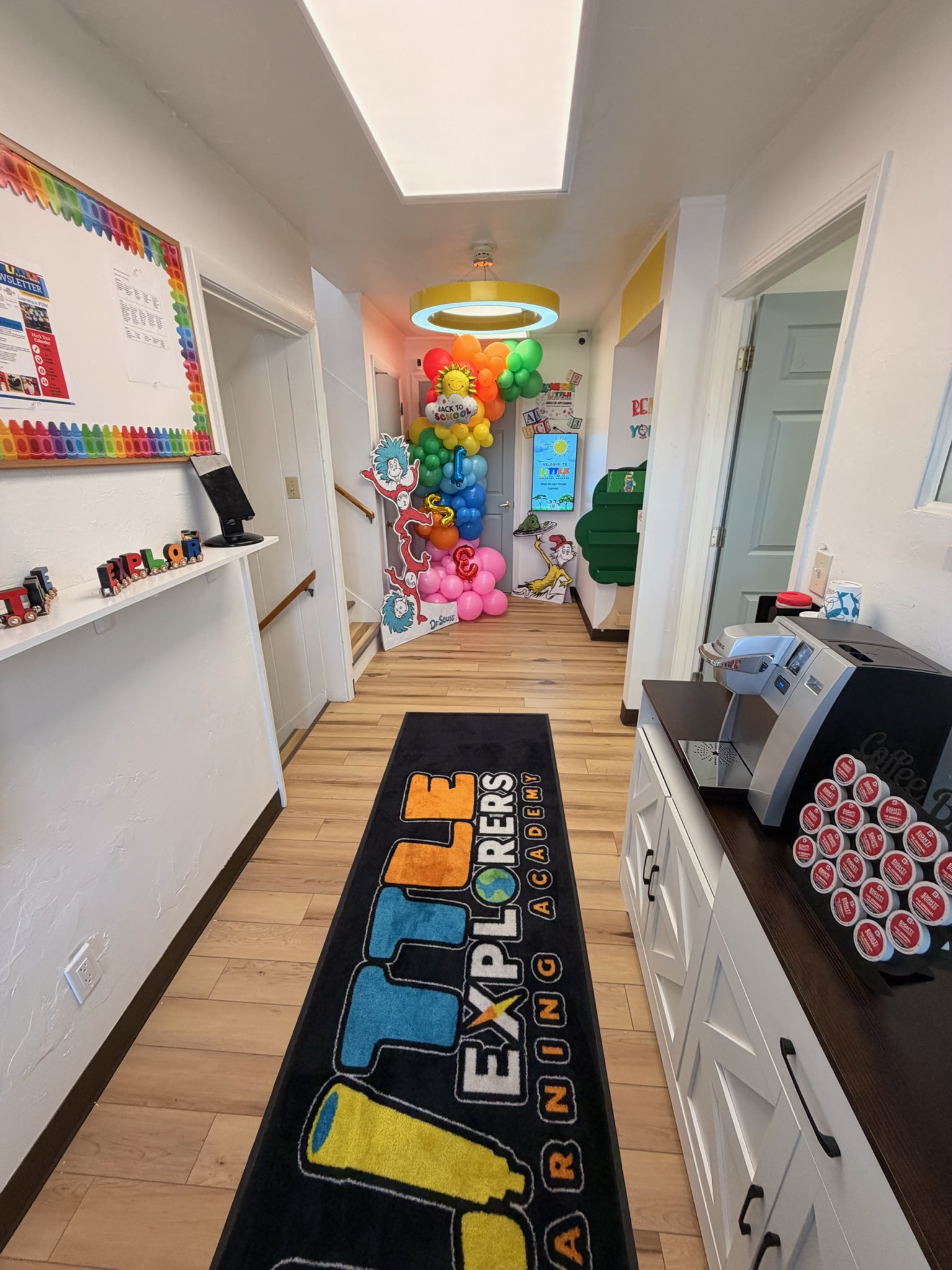 Looking down the Little Explorers hallway toward the rooms, with the school name on the floor runner